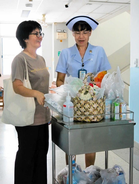 緩和ケアチームの看護師（右）と話す浦崎雅代さん＝タイ北部・ウッタラディット県