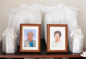 隣に並ぶ金森さん夫妻の骨つぼと遺影＝西宮市内