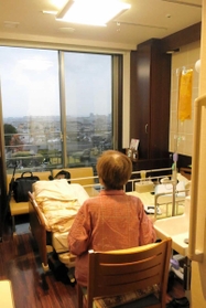 病室から窓の外を眺める山田麻子さん＝芦屋市立芦屋病院