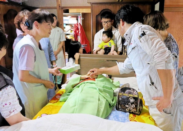 自宅で亡くなった廣尾すみゑさんを囲む家族や友人、看護師ら＝小野市