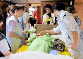 自宅で亡くなった廣尾すみゑさんを囲む家族や友人、看護師ら＝小野市