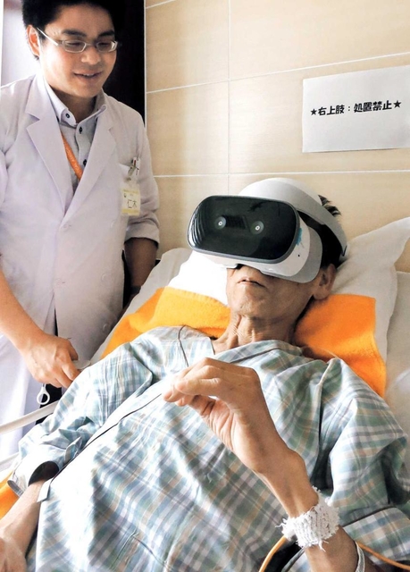 仮想現実（ＶＲ）の装置を着け、自宅の映像を見る男性＝芦屋市朝日ケ丘町