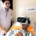 仮想現実（ＶＲ）の装置を着け、自宅の映像を見る男性＝芦屋市朝日ケ丘町