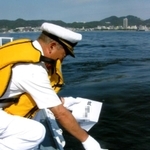 海洋散骨する「海晃」の政水宏さん。対岸には神戸の街が見える（政水さん提供、画像の一部を加工しています）