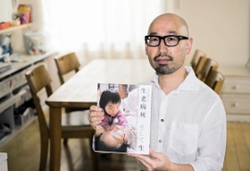 「次世代に『命』をつなぐため、自分の全てをぶつけたかった」と新著を手に語る国森康弘さん＝大津市