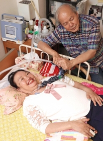 口文字で会話をする米田晴美さん（手前）と夫の裕治さん。昨年は奈良県の中学校に招かれ、話をした。「どこへでも行く。楽しいから」＝西宮市内（撮影・吉田敦史）
