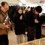 津知公園の追悼式典で献灯し、手を合わせる住民ら＝２０１３年１月１７日、芦屋市津知町