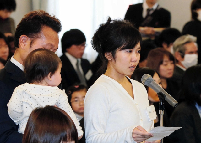 夫と長女に見守られ手紙を朗読する女性＝２０１５年１月１１日