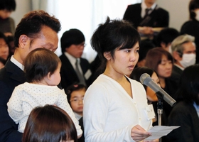 夫と長女に見守られ手紙を朗読する女性＝２０１５年１月１１日