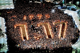 竹灯籠の火で「１・１７」の文字が浮かび上がった震災２０年の１・１７のつどい＝２０１５年１月１７日、神戸市中央区加納町６