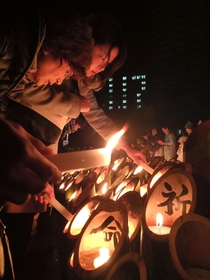 竹筒にろうそくの火を灯す人たち＝１７日早朝、神戸市中央区加納町６、東遊園地（撮影・冨居雅人）