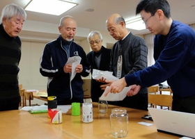 住民から提供された瓶に和紙を巻く冨岡修平委員長（左から２人目）ら＝神戸市灘区摩耶海岸通１