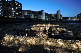 「生」のオブジェをライトアップし、黙とうする市民ら＝１６日夕、宝塚市の武庫川中州（撮影・三津山朋彦）