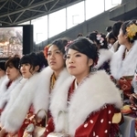 大型スクリーンに映し出される阪神・淡路大震災当時の街の様子を見つめる新成人＝１１日午後、神戸市兵庫区御崎町１、ノエビアスタジアム神戸（撮影・風斗雅博）
