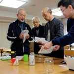 住民から提供された瓶に和紙を巻く冨岡修平委員長（左から２人目）ら＝神戸市灘区摩耶海岸通１