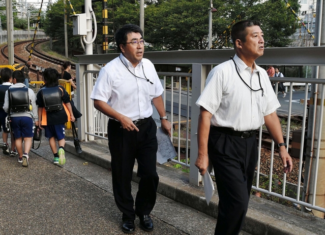 通学路とその周辺で安全面の点検をする神戸市教育委員会の職員ら＝２６日午前８時ごろ、神戸市長田区房王寺町３（撮影・宮路博志）