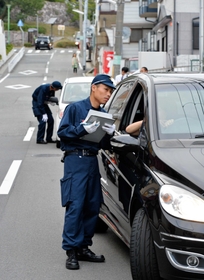 車を停車させて聞き取りを行う警察官＝１７日午後５時３２分、神戸市長田区房王寺町２