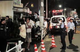 遺体が見つかった現場周辺では、駆け付けた地域住民らが不安そうな表情を浮かべた＝２３日午後９時１０分、神戸市長田区長田天神町１