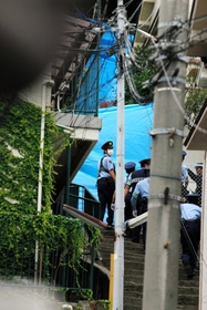 美玲ちゃんの遺体が発見された現場に向かう捜査関係者ら。左は君野容疑者が住んでいた文化住宅＝２４日午前７時５６分、神戸市長田区長田天神町１
