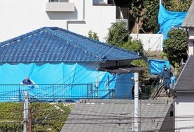 ブルーシートに覆われた君野康弘容疑者宅を調べる捜査関係者＝２７日午前９時５１分、神戸市長田区長田天神町１