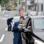 車を停車させて聞き取りを行う警察官＝１７日午後５時３２分、神戸市長田区房王寺町２
