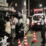 遺体が見つかった現場周辺では、駆け付けた地域住民らが不安そうな表情を浮かべた＝２３日午後９時１０分、神戸市長田区長田天神町１