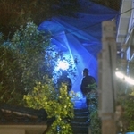 袋に入った遺体が発見された雑木林（奥）＝２３日午後９時８分、神戸市長田区長田天神町１