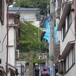 女児の遺体が発見された現場へ向かう捜査員。左上の青瓦の文化住宅が容疑者の自宅＝２４日午前１０時３３分、神戸市長田区長田天神町１