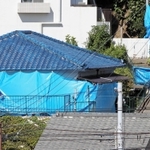 ブルーシートに覆われた君野康弘容疑者宅を調べる捜査関係者＝２７日午前９時５１分、神戸市長田区長田天神町１
