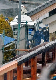 ３人が亡くなった平野浩之さん方での調べを終え、引き揚げる捜査員。手前は２人が犠牲になった平野毅さん方＝９日午後、洲本市中川原町中川原