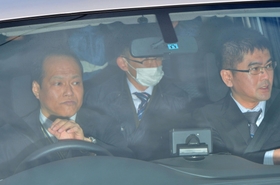 青いフードのようなものをかぶり送検のため車で洲本署を出る平野達彦容疑者（後列左）＝１０日午前１１時８分、洲本市山手２