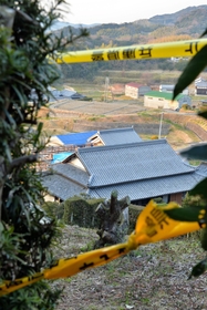 平野毅さんらの遺体が見つかった民家。周辺は規制線が張られている＝１４日午後５時３１分、洲本市中川原町中川原