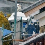 ３人が亡くなった平野浩之さん方での調べを終え、引き揚げる捜査員。手前は２人が犠牲になった平野毅さん方＝９日午後、洲本市中川原町中川原