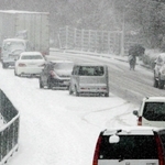 路面に積もった雪で走行できなくなり、立ち往生した乗用車＝２０１４年２月、神戸市内