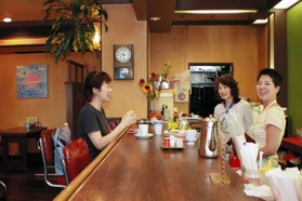常連客と会話を弾ませる山門由佳さん（右）、金保美恵子さん（右から２人目）＝神戸市灘区岩屋北町４