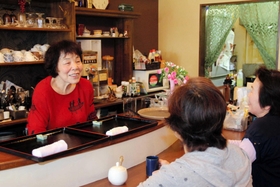 常連客との会話を楽しむ店主の的山初代さん＝明石市硯町２