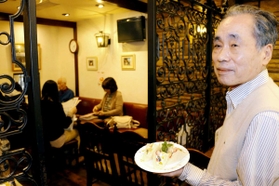 名物のフルーツサンドを手にする宮西昭広さん＝尼崎市建家町