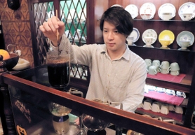 注文を受けてサイホンでコーヒーを抽出する原田宇真さん＝神戸市須磨区飛松町１