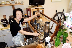海をイメージしたインテリアが目を引く店内。店主の北輝子さんが１杯ずつ丁寧にコーヒーを入れる＝神戸市中央区北野町４