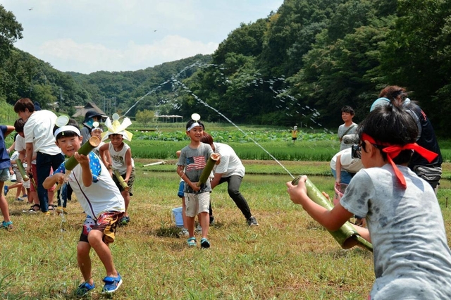 水鉄砲で水を飛ばし合う児童ら＝神戸市北区山田町藍那