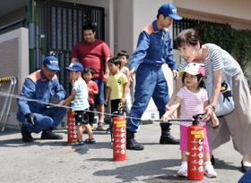 消火器の使い方を学ぶマンションの住人ら＝神戸市北区大脇台