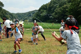 水鉄砲で水を飛ばし合う児童ら＝神戸市北区山田町藍那