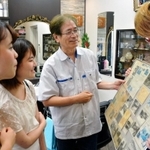 「理容なかもと」で２代目店主の中本博行さん（右から２番目）から話を聞くきたっ子むすめの２人＝北区鈴蘭台北町１