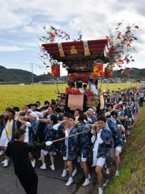 黄金色に染まる水田の間を進む布団太鼓＝神戸市北区淡河町勝雄