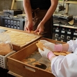 できたての炭酸せんべいの形成作業＝三ツ森本店