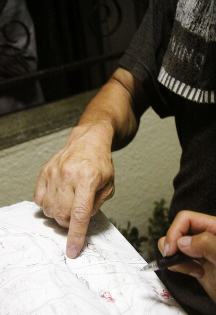 男から逃れた体験を地図のコピーを指さしながら語った男性＝１７日夜、神戸市北区