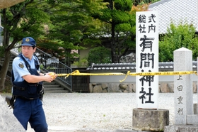 容疑者の男が逮捕されたとみられる場所を規制する兵庫県警の警察官＝１６日午前１１時１分、神戸市北区、有間神社