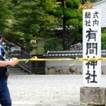 容疑者の男が逮捕されたとみられる場所を規制する兵庫県警の警察官＝１６日午前１１時１分、神戸市北区、有間神社