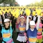 阪神・淡路大震災からの復興の象徴「ひまわり」をイメージした黄色い手袋がスタート前に配られ、２万人のランナーが両手を掲げて「感謝と友情」を表現した＝２３日、神戸市中央区磯辺通４（撮影・峰大二郎）