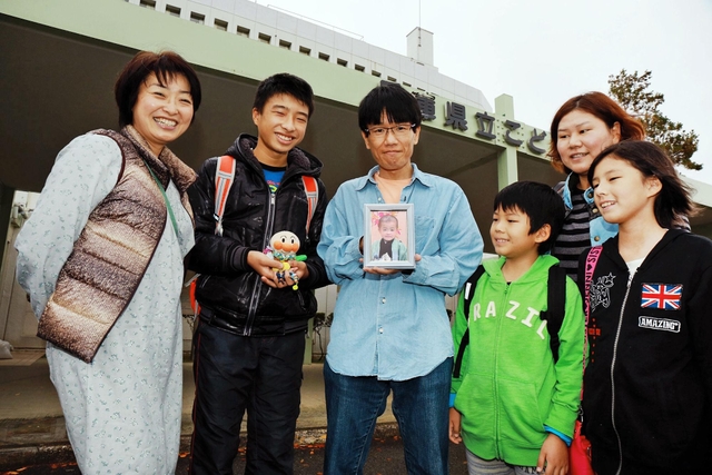 次男孝多君の写真を持つ高岡正明さん（中央）と（左から）妻の佐奈恵さん、長男の祐歩君。（右から）山口莉穂さん、幸子さん、勇飛君＝神戸市須磨区高倉台１、県立こども病院